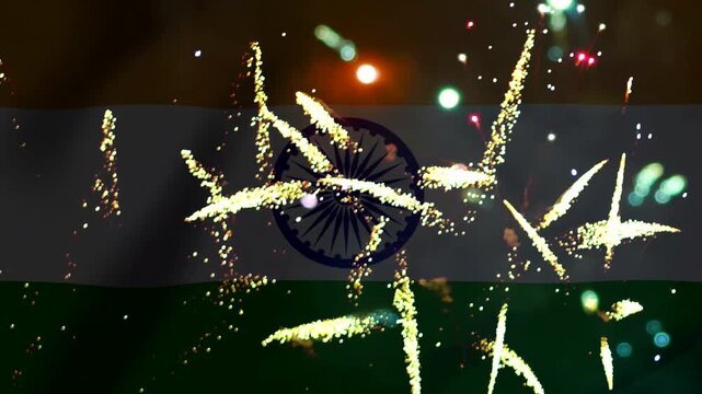 Bright golden fireworks exploding in front of the waving flag of India during celebration