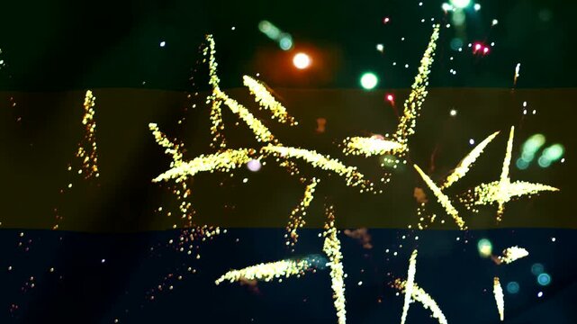 Bright yellow gold fireworks exploding against the national flag of Gabon