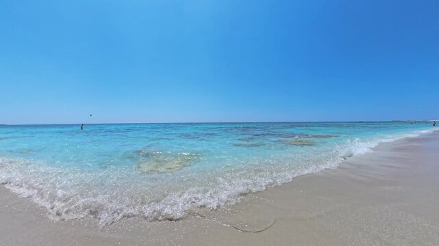 Walking POV exploring Mari Ermi Sardinia with gentle waves on quartz sand and turquoise Mediterranean water