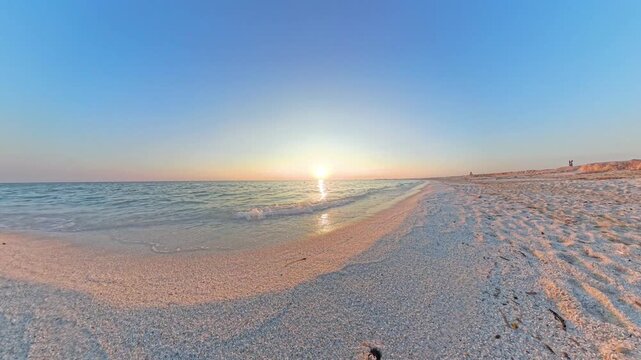 Static POV soft red sunset at Mari Ermi Sardinia with warm reflections on calm Mediterranean sea