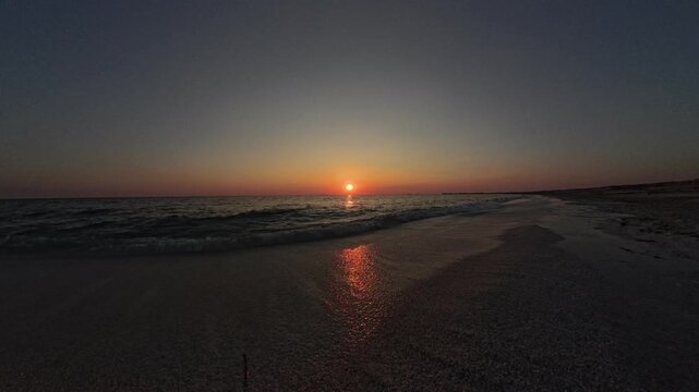 Static POV lighter red sunset at Mari Ermi Sardinia with sun visible and warm sea reflections