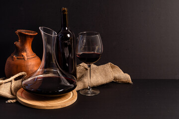 Fototapeta premium Red wine decanter and glass with dark copy space