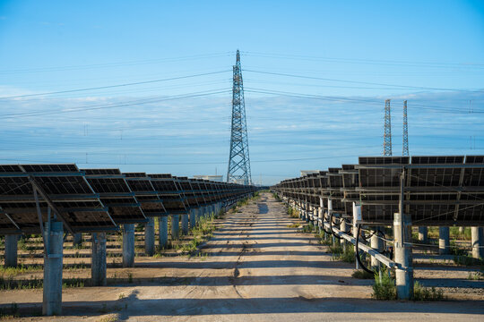 Solar Power Farm With Transmission Towers Under Clear Sky