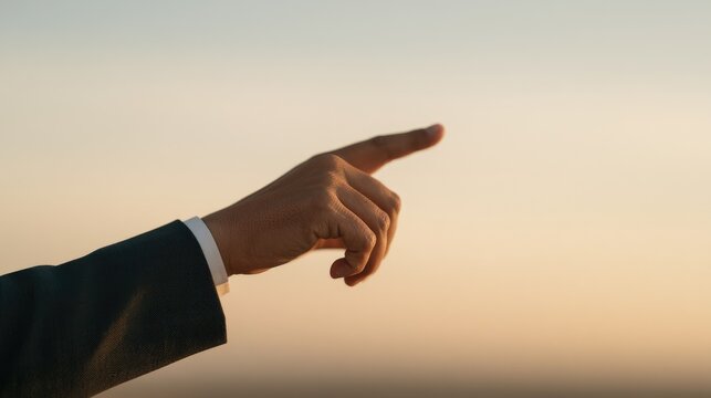 Hand Pointing Forward Against a Softly Blurred Sky Background.