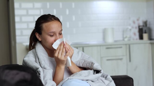 Sick girl with runny cold symptoms resting at home, representing illness, flu and seasonal infection