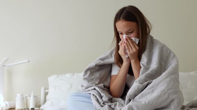 Sick girl with runny cold symptoms resting at home, representing illness, flu and seasonal infection