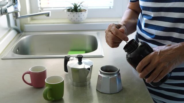 Senior Woman Filling Moka Pot with Coffee