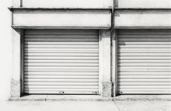 Closed storefronts with metal rolling security shutters on a city