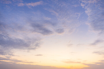 Fototapeta premium Serene Pastel Sunset Sky,A tranquil and serene sunset sky featuring soft, delicate clouds transitioning from a warm golden-orange glow at the horizon to a calm pastel purple and blue above, suitable.