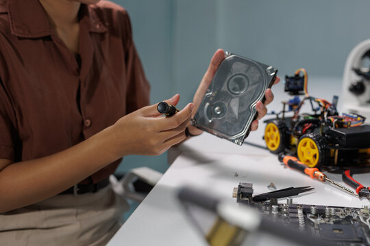 Engineer repairing computer hard drive and robotics