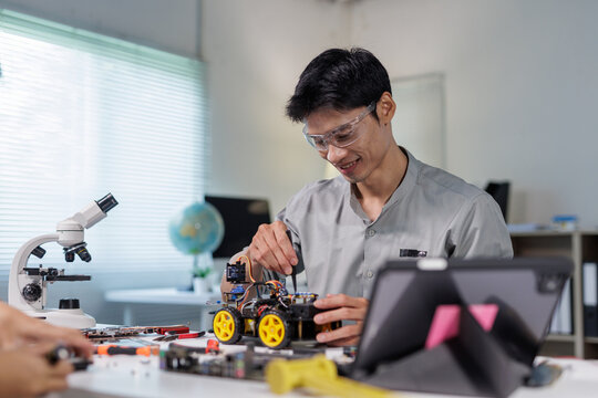 Young engineer building robot car in workshop