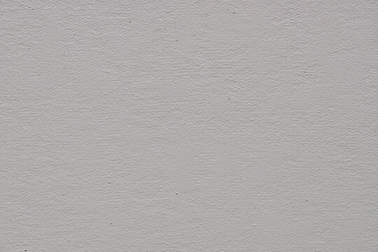Abstract beige stucco wall texture background with a subtle rough finish and copy space.