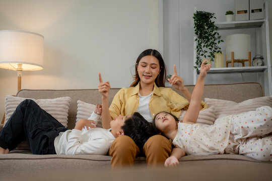 Mother telling story to children pointing up