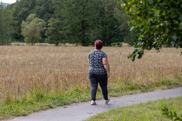 Naklejka premium Woman walking on path in field during day