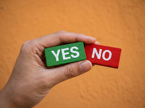 Hand holding green yes and red no signs