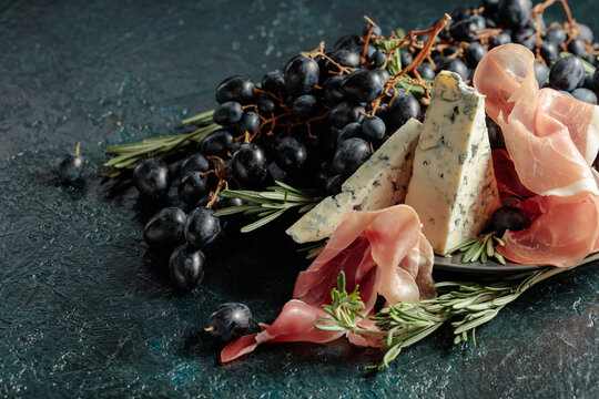 Prosciutto with blue cheese, grapes, and rosemary.