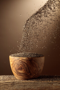 Chia seeds is poured into a wooden bowl.