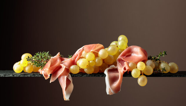 Mediterranean snacks. Grapes with prosciutto and thyme.