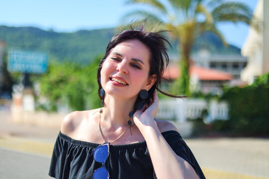 Happy brunette woman tourist exploring a new country on hot sunny day enjoying her summer vacation travel and discovering foreign culture.