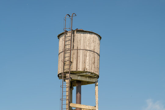 Rustic water tower standing tall against a clear blue sky capturing a moment of rural charm and simplicity