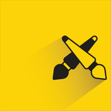 crossed brushes icon with shadow on yellow background