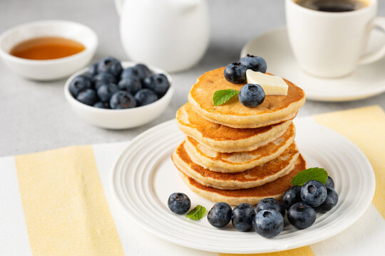 Tasty breakfast pancakes with blueberries, butter and maple syrup