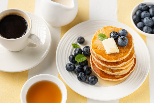 Tasty breakfast pancakes with blueberries, butter and maple syrup