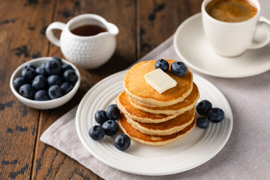 Tasty breakfast pancakes with blueberries, butter and maple syrup