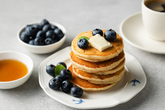 Tasty breakfast pancakes with blueberries, butter and maple syrup