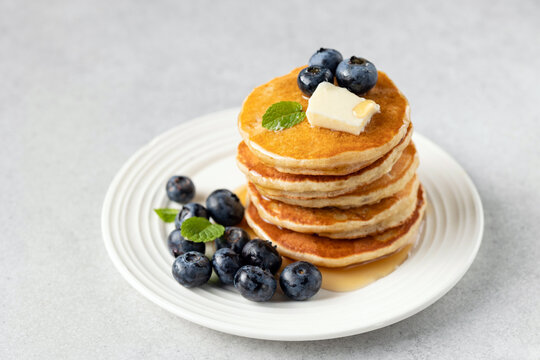 Tasty breakfast pancakes with blueberries, butter and maple syrup