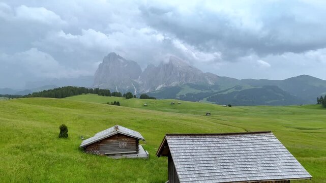 Aerial View of Alpine Huts and Dramatic Clouds at Alpe di Siusi
