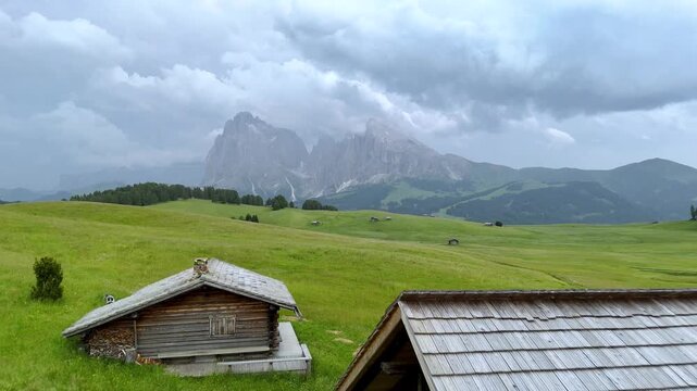 Backward Drone Flight Over Alpe di Siusi and Shepherd Huts
