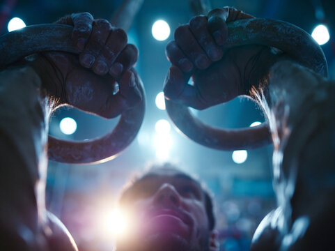 Male Gymnast Gripping Gymnastic Rings During Competition