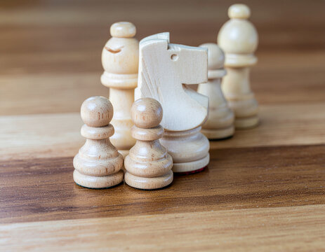light wooden chess pieces including knight pawns and bishop placed on a polished wooden surface