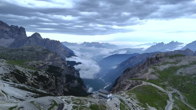 Backward Drone Flight from Auronzo Refuge in Foggy Dolomites
