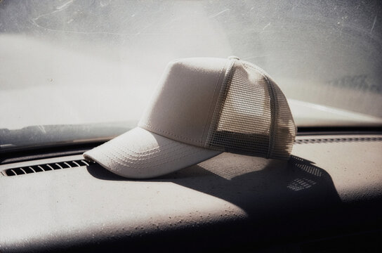 White trucker cap mockup template on car dashboard with sunlight