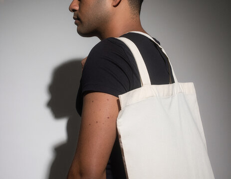 White canvas tote bag mockup template worn by person in side view