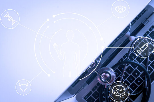 Top view of a stethoscope on a laptop keyboard with a digital human body and medical network graphic overlay. Concept of health tech, telemedicine, AI in healthcare, and digital data analysis.