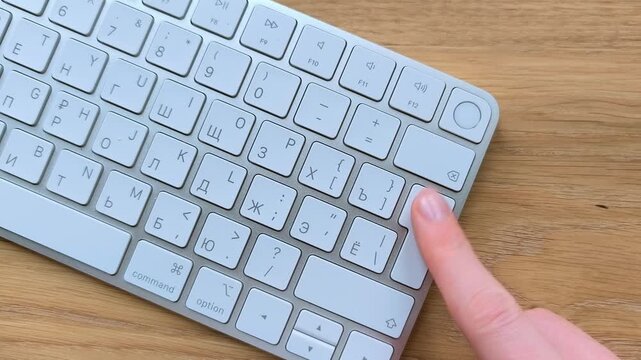 Index finger pressing the Enter key on a keyboard. Top view of a hand confirming action during computer use. Close-up moment of everyday digital interaction..