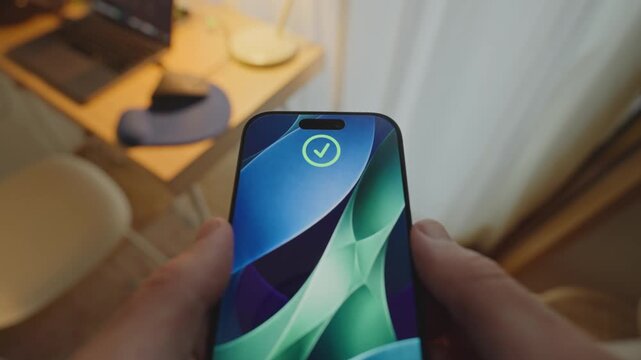 Personal perspective of person holding smartphone as device recognize the face. Facial recognition technology opening and enabling access unlocking phone. POV of person indoors in house or apartment