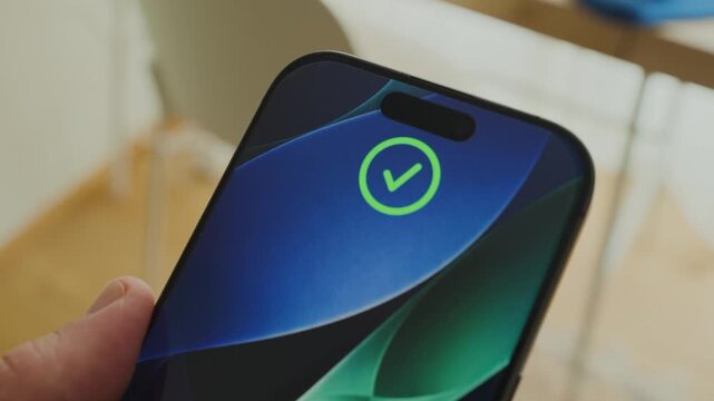 Close up on phone recognizing facial features and unlocking device for access. Smartphone close up on screen as hand holds it. Face unlock technology using biometrics enabling usage of device