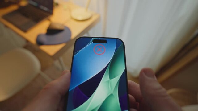 POV of hands holding phone as facial recognition fails to recognize user. Error trying to access device with biometrics face identification technology. Personal perspective shot denying access