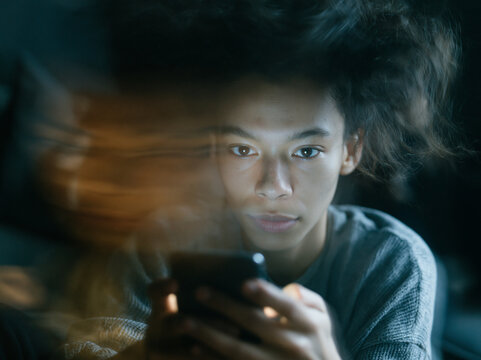 Teenager Using Smartphone in Dark with Motion Blur
