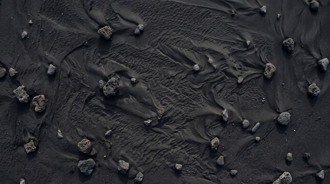 Volcanic black sand beach with textured rocks