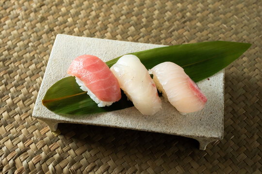 Japanese sushi with tuna, sea bream and amberjack on a bamboo leaf