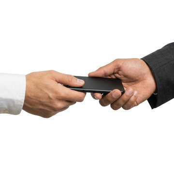 Close-up de duas m&atilde;os de homens de neg&oacute;cios passando um smartphone preto, representando compartilhamento de informa&ccedil;&otilde;es e tecnologia, isolado em fundo branco.