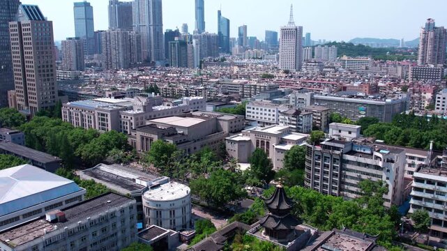 A blend of traditional Chinese architecture and modern high-rise buildings in an urban cityscape with greenery.