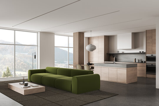 Modern open plan interior design with olive sofa, wood kitchen, panoramic windows, and mountain views in a refined residential living space. 3D Rendering