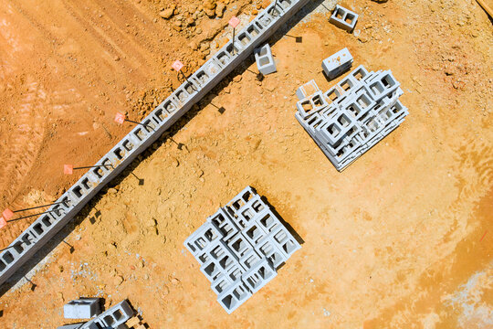 Blocks are set on dirt surface at construction site with foundation outlines nearby