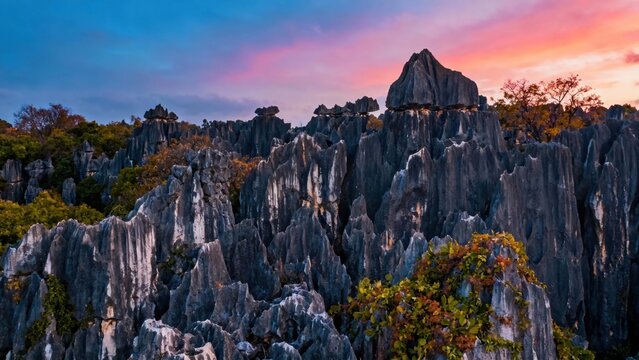 Dramatic limestone karst formations at sunset with vibrant sky and autumn foliage